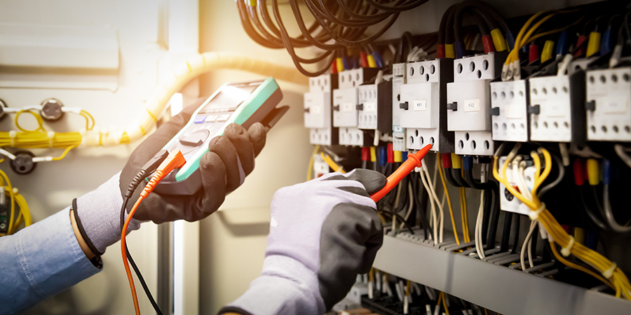 Field Service engineer using digital multi-meter measuring equipment to checking electric current voltage at circuit breaker and cable wiring system in main power distribution board. Field Service engineer using digital multi-meter measuring equipment to checking electric current voltage at circuit breaker and cable wiring system in main power distribution board.